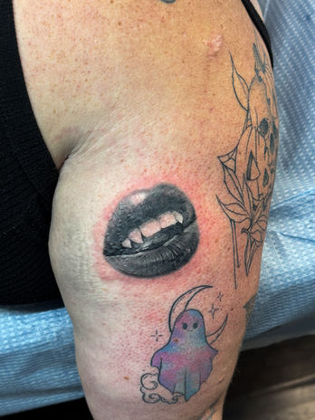 Realistic rendering of vampire lips, done in black and grey realism, placed on the back of the upper arm. Done in Kelowna Tattoo Studio, Ash & Ink.