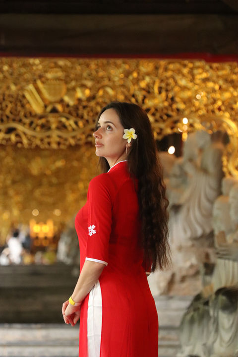 Elena in a traditional Vietnamese dress standing at Bai Dinh Pagoda