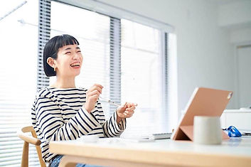 オンラインレッスンを受けながら、体を仰け反りながら爆笑する女性