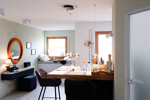 Helles, modernes Esszimmer mit gemütlicher Fensterbank und Spiegel, das durch natürliche Farben eine harmonische Raumgestaltung betont.