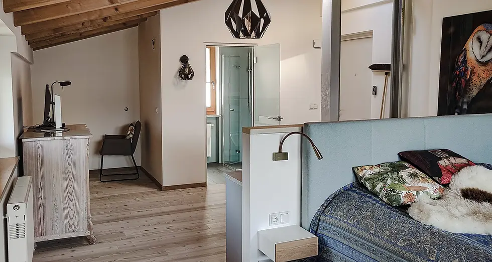 Innenaufnahme einer Maisonette-Wohnung mit Holzdecke, heller Gestaltung und maßgefertigtem Mobiliar.