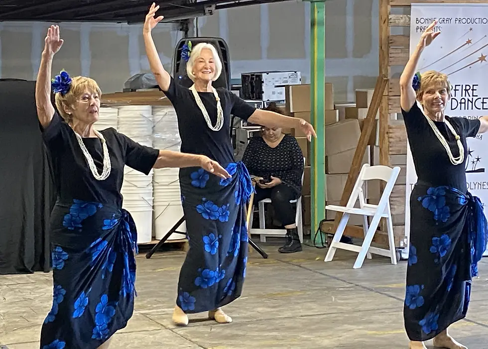 Adult women doing hula dancing in blue skirts at a dance studio in Bradenton.