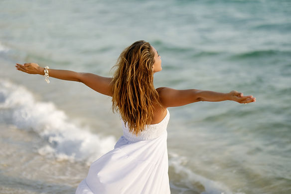 back-view-woman-feeling-free-while-standing-by-sea-with-her-arms-outstretched.jpg