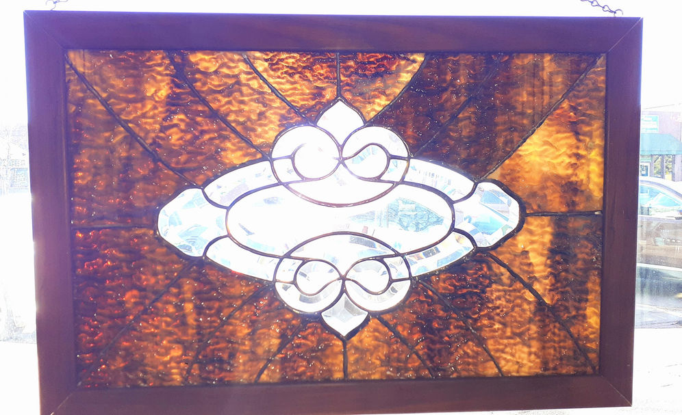 Framed stained glass panel with central fleur-de-lis motif