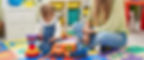 teacher-toddler-playing-with-cars-toy-sitting-floor-kindergarten.jpg