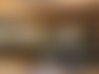 Interior of Chit Chat Coffee in Los Angeles featuring several Naaya Poppy ceramic wall sconces mounted on a light-colored wall above a wooden bench seating area. The space is bright with modern furniture and large glass windows.