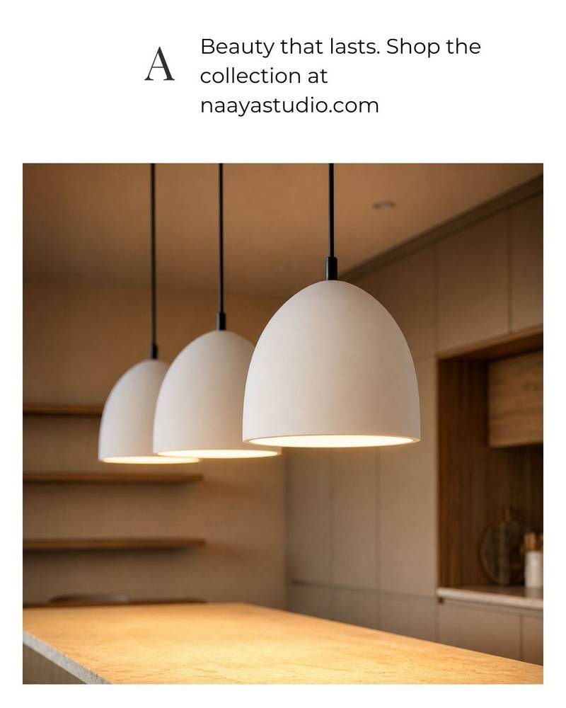 Three minimalist white ceramic pendant lights illuminating a modern luxury kitchen island.