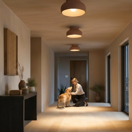 Woman walking down a modern hallway illuminated by Naaya three warm terracotta ceramic flush mount lights on the ceiling.