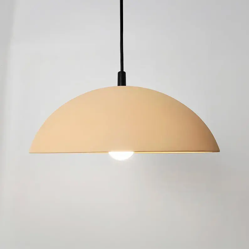 Elegant minimalist dome pendant in a soft, warm peach finish radiating a cozy, diffused downlight.