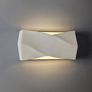 Minimalist folded wall sconce glowing warmly against a dark wall, highlighting its modern architectural silhouette.