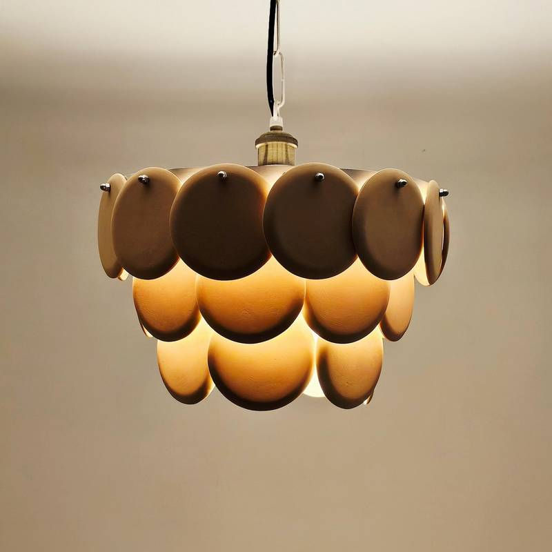 Elegant cascading disc chandelier emitting a cozy, ambient glow from within its sculptural organic form.