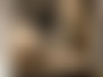 Moody wabi-sabi bathroom design featuring a white handcrafted ceramic pendant light hanging low over a stone vessel sink and wooden vanity.