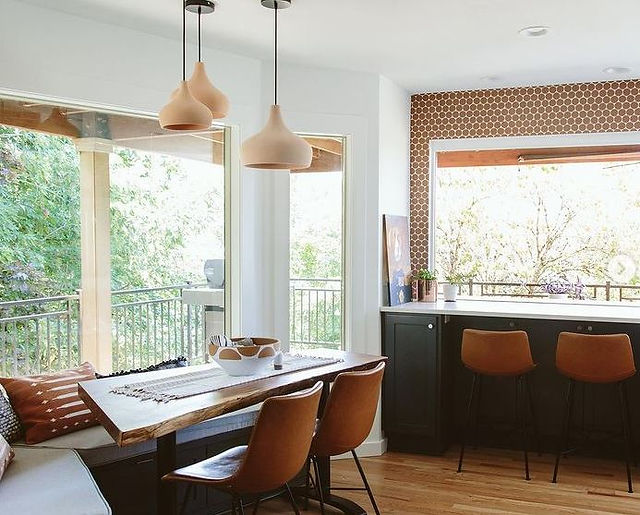 Three Morning Bell pendant lights in a staggered fashion over breakfast nook table
