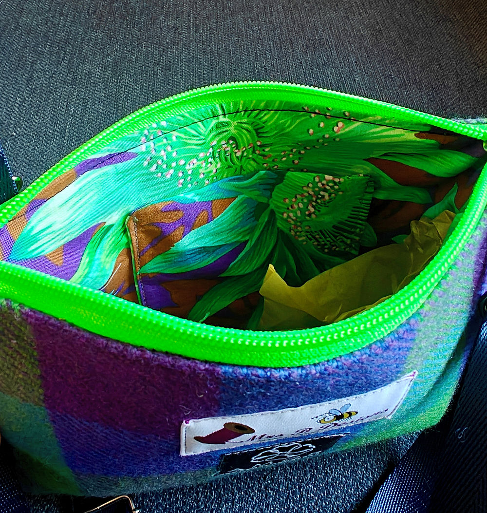 Looking down and info a small open bag. The ziper and inside are a super-bright green colour.