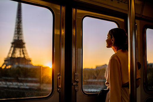 Young woman enjoying view on the Eiffel tower from the subway train during the sunrise in