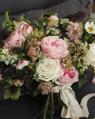 Romantic bridal bouquet tied with silk ribbon. Colours are muted and harmonised.