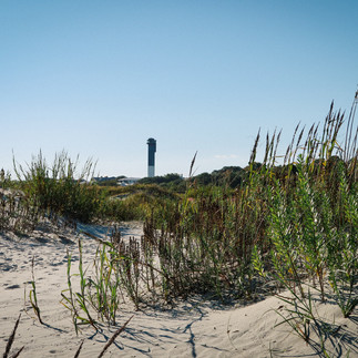 lighthouse on the horizon of a beach