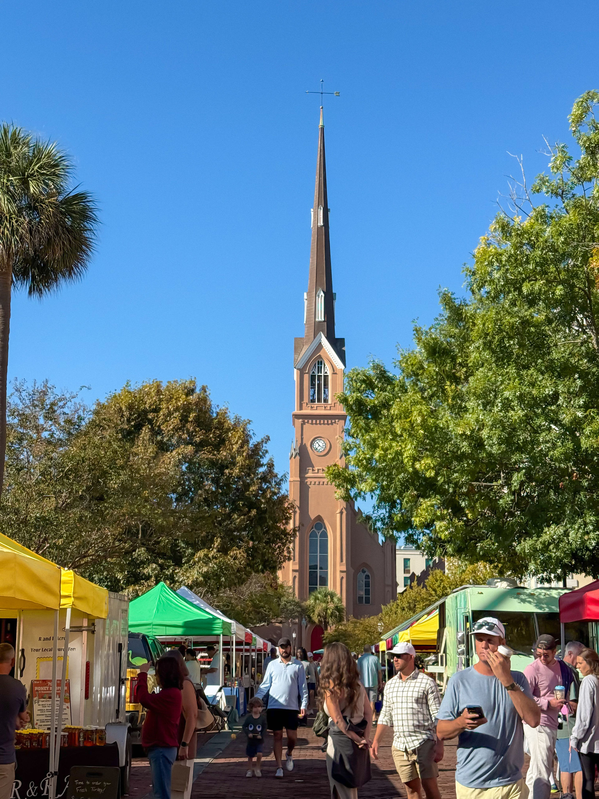 a tall church in the background of a farmer's market
