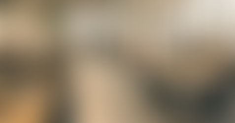 Escritório aberto com equipes em reunião; mulher apresenta. Quadros exibem Sprint Review e Metas 2027.