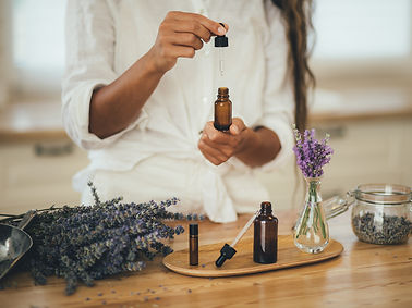 Young woman applying natural organic essential oil on hair and skin. Home spa and beauty r