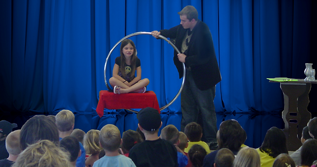 Bronson levitating a student in the air at the end of Magic in the Library Live. (Not available in all areas).