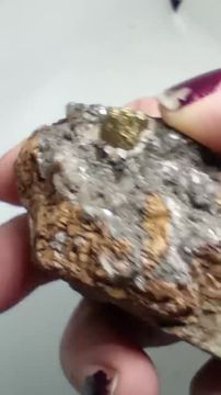Thumbnail: Defined chalcopyrite crystal balanced on limestone/calcite with other minerals.