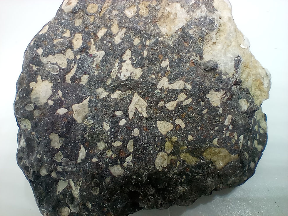 Thumbnail: Amygdaloidal basalt with colourful light pink to white vugs.