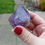 Thumbnail: A deep purple, large amethyst point with a little clay on the bottom.
