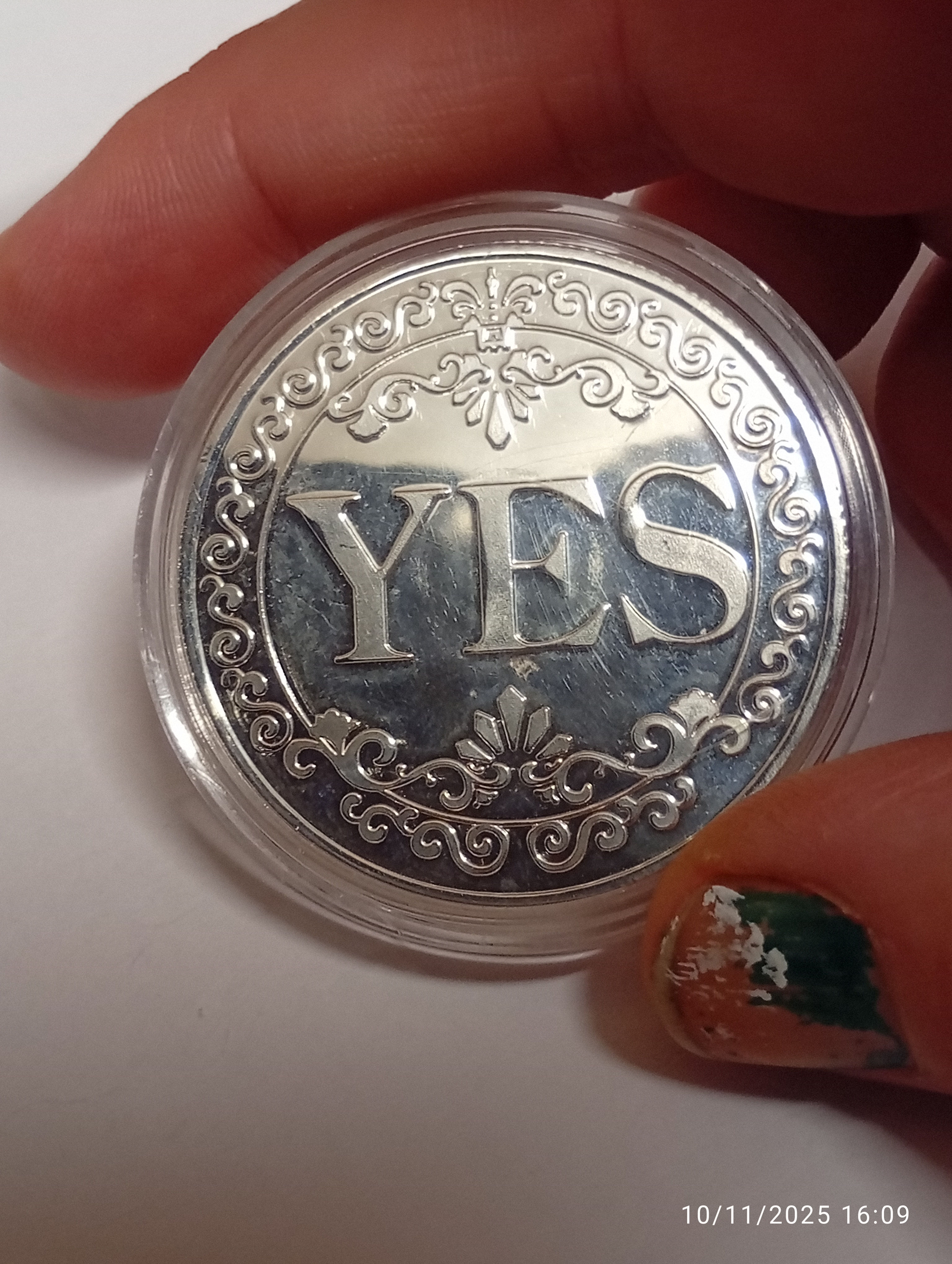 one side of a silver coin which says yes on one side and no on the other.