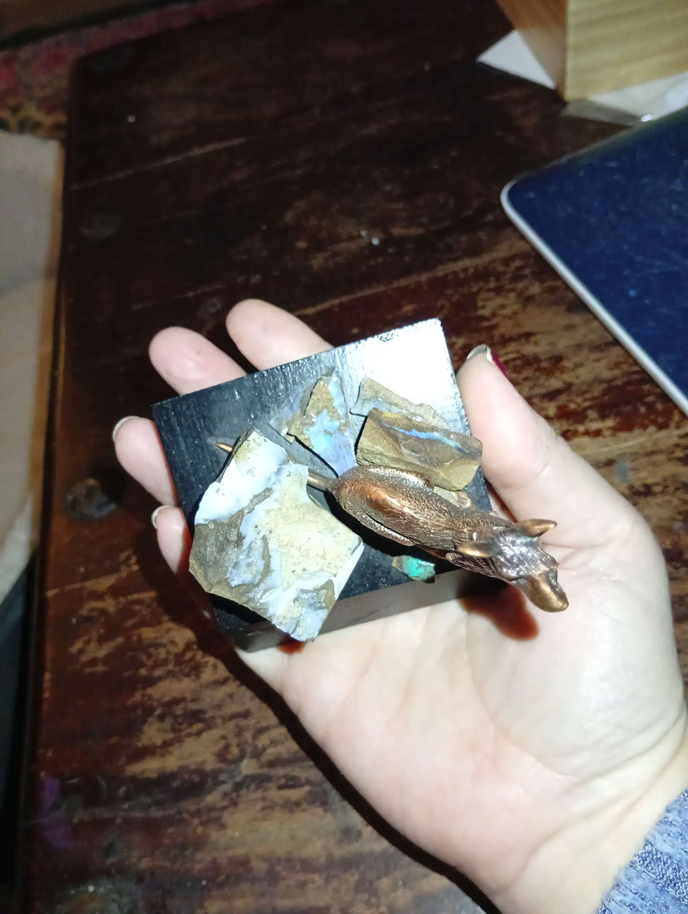 Miniatura: a kangaroo figurine in brass or bronze on a stand which has boulder opal pieces on it.