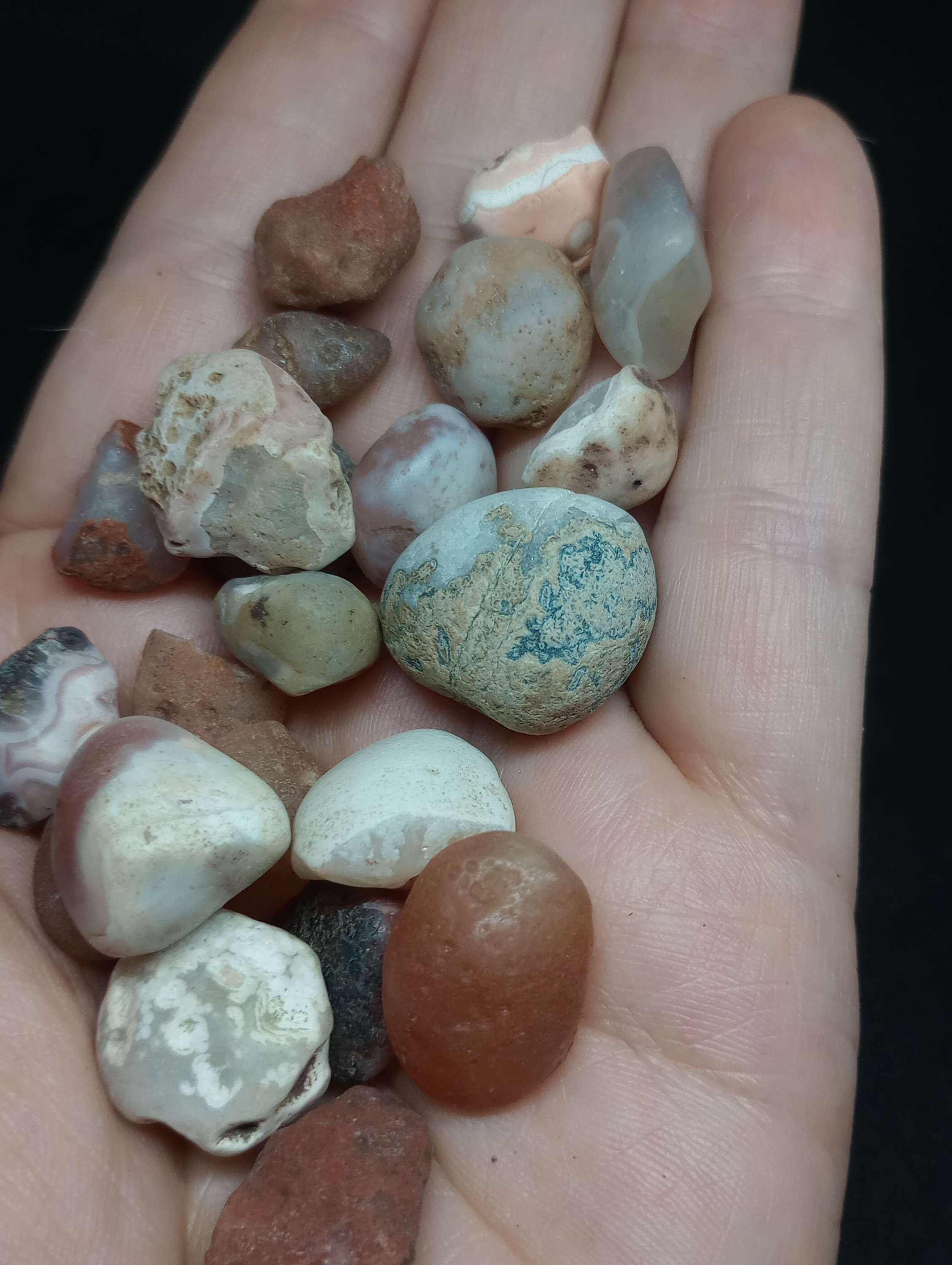 A literal handful of small agate pebbles/ chalcedony pebbles in different colours