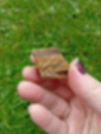 A chunk of rough tiger's eye crystal supports an incense stick through a hole drilled into it.