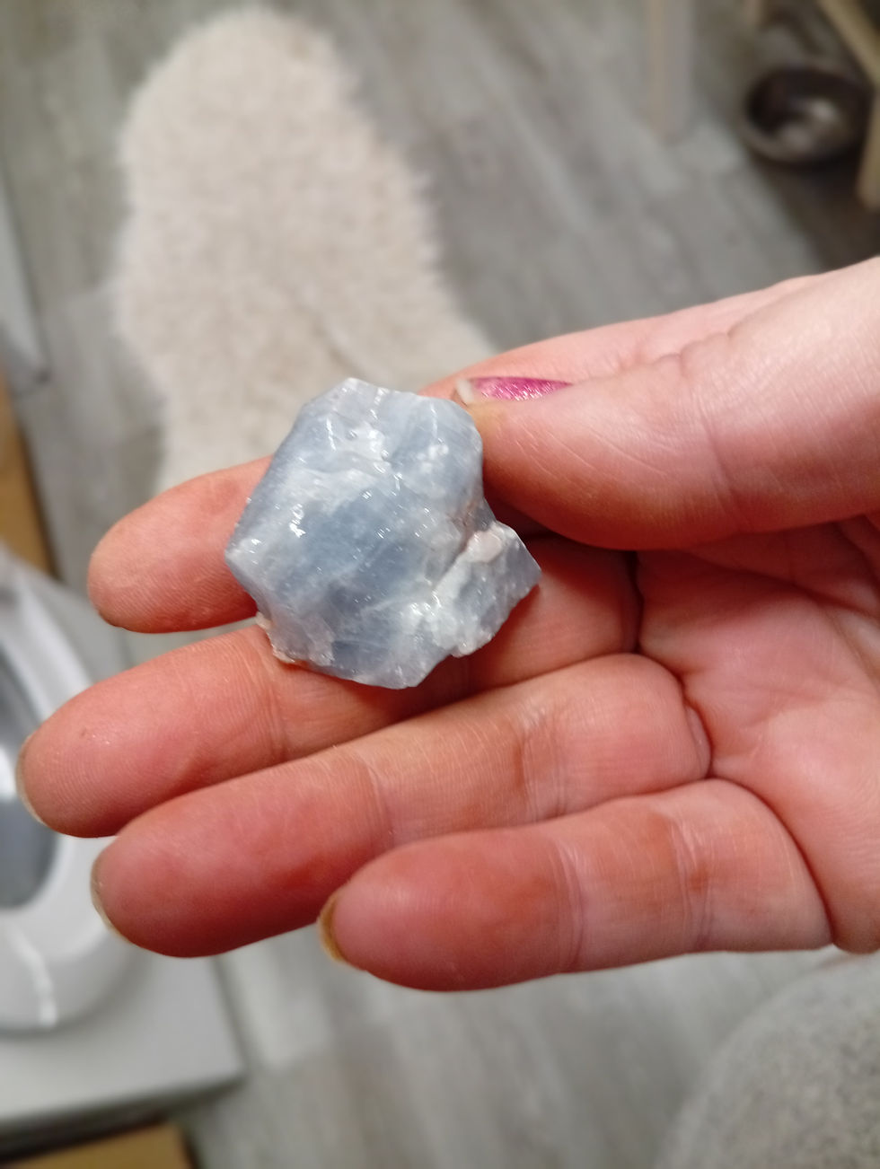 A piec of blue calcite held in a hand