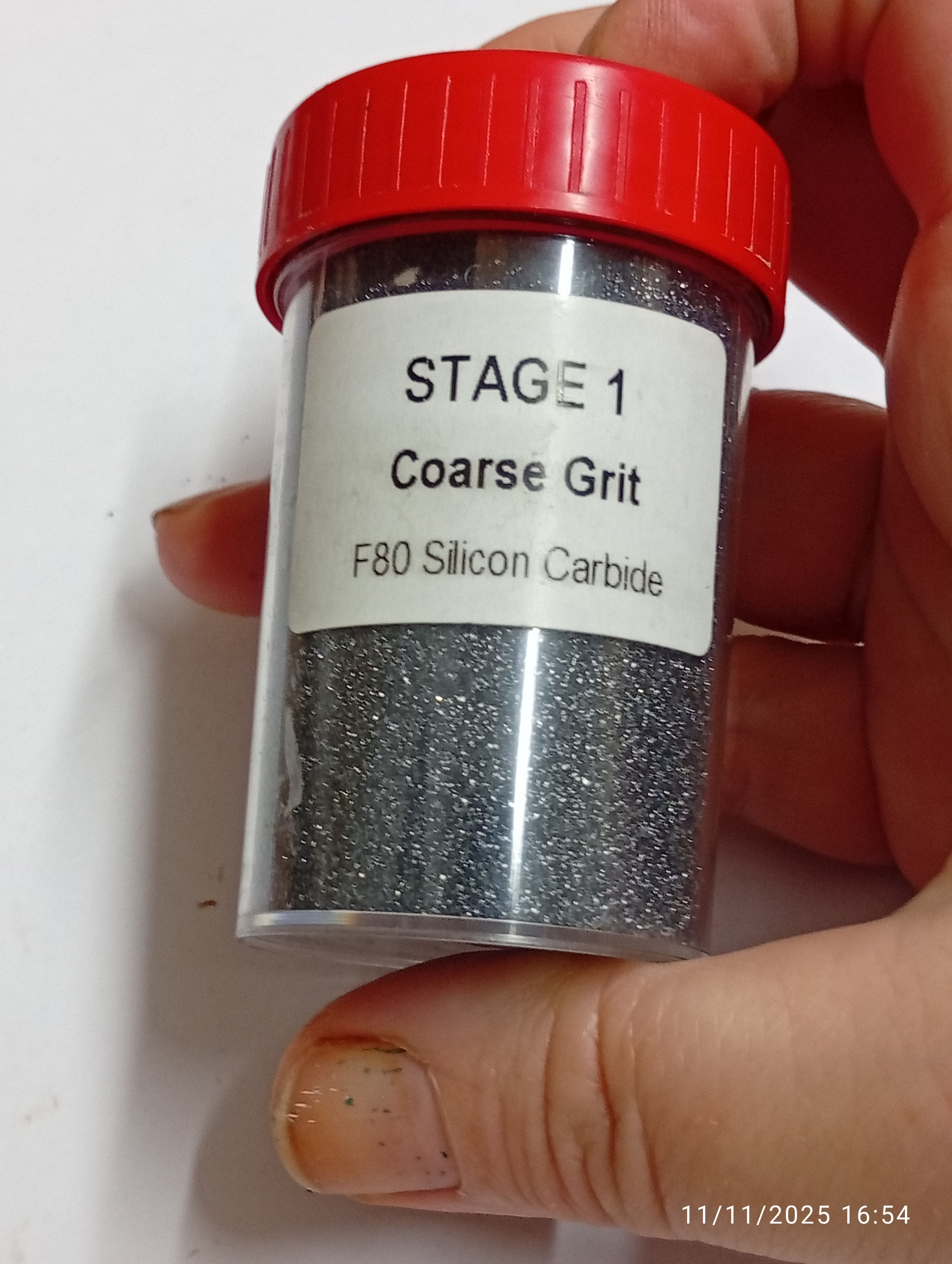 a small plastic (reusable) tub containing F80 grit silica carbide for rock tumbling stage one.