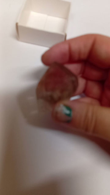 Thumbnail: the smoky quartz crystal held against a white background