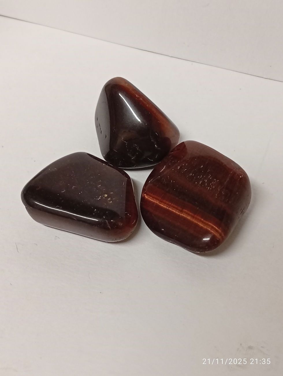 red tiger's eye crystals that are tumbled and shiny.