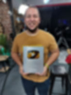 Joseph Baba Ifa Holding his YouTube 100k SUbscribers Button