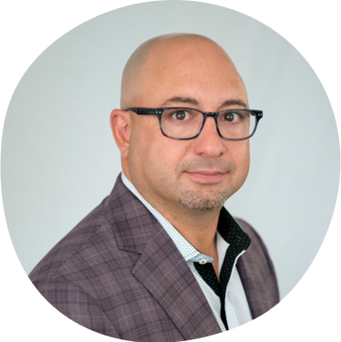 David Mattucci, Board Member, wearing a gray patterned blazer and glasses and a thoughtful expression