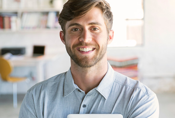 Smiling Young Man with Tablet, as we are always happy to help design, build and service our clients