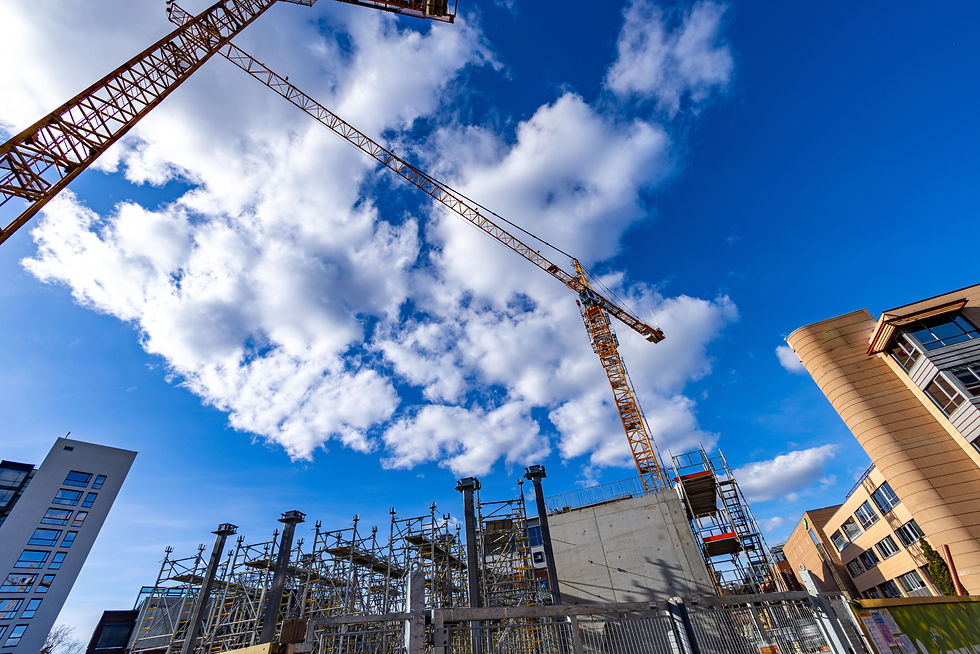 Eye-level view of a modern urban development site with cranes and construction equipment