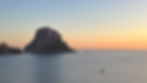 Sunrise over Es Vedrà rock near Ibiza with golden light reflecting on the Mediterranean Sea