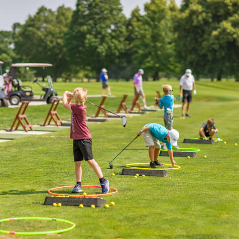 boy practicing driving club at junior golf academy