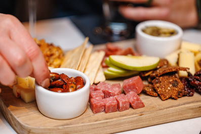 hand grabbing at nuts on charcuterie board