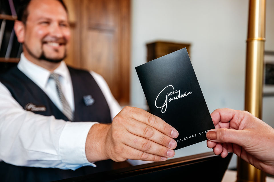 Front desk agent handing over room key to guest 