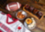 Cheese curds and cheese dip paired with a University of Wisconsin football jersey, a Nike football, and a beer flight.
