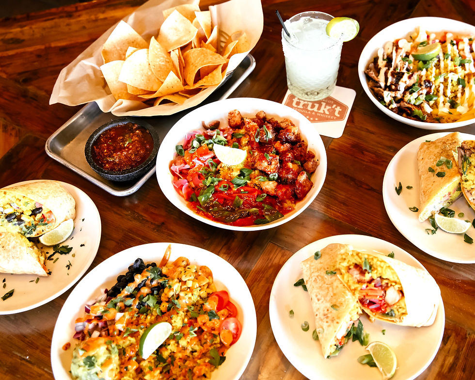 full spread of burritos, tacos, chips, and a margarita