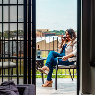 woman sitting on balcony drinking wine 