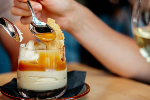 Spoon dipping into butterscotch budino desser