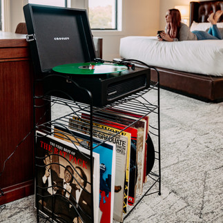 record player on stand with many vinyls on shelf