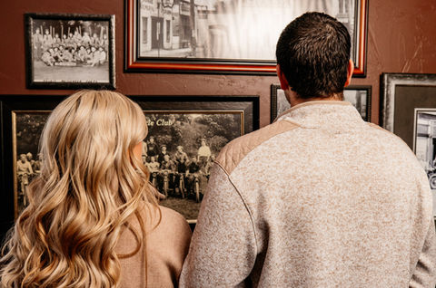 couple looking at photos displayed in Merrill & Houston's 